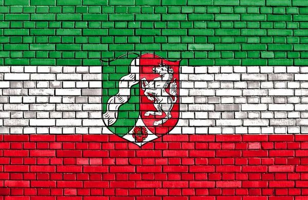 Wappen NRW auf Steinwand mit NRW Flaggenfarben